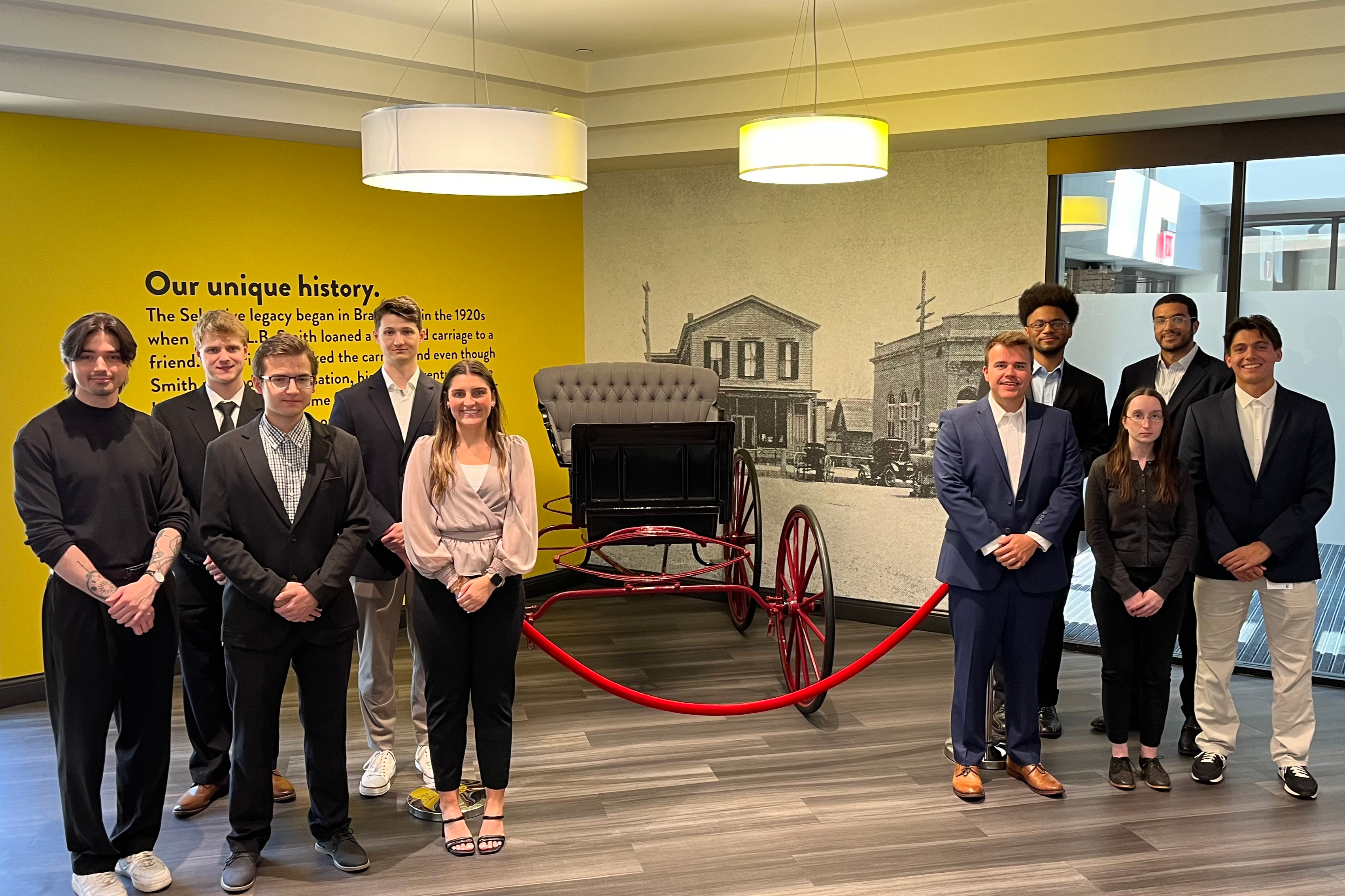Ten members of a recent Selective IT Early Career Development Program cohort stand in the corporate headquarters.