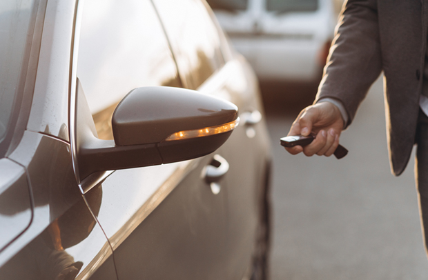 Man in suit unlocked a high-end car protected by the Selective Edge auto insurance policy enhancement from Selective.